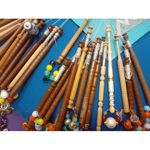 164 - A quantity of lace bobbins on 2 lace-making cushions to include wooden, bone and plastic bobbins, so... 