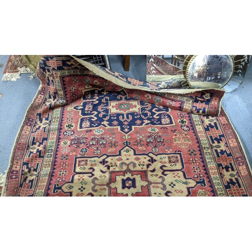 217 - A Turkish hand woven red ground runner having five central motifs and repeating pattern, 322cm x 140... 