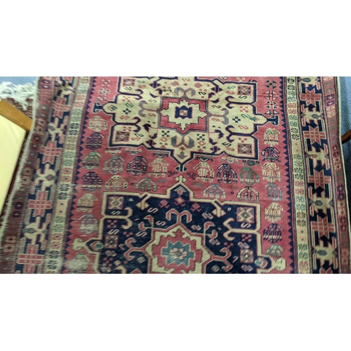 217 - A Turkish hand woven red ground runner having five central motifs and repeating pattern, 322cm x 140... 