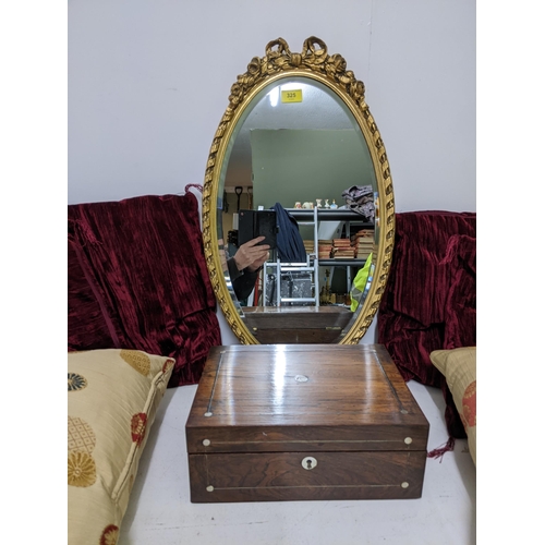 325 - An oval gilt framed wall mirror with flower head and bow decorations, bevelled glass plate, Victoria... 