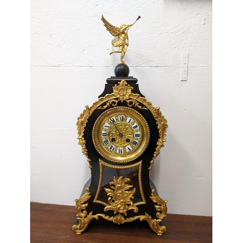 359 - A late 20th century reproduction ebonized and gilt metal French style clock surmounted by a figure L... 