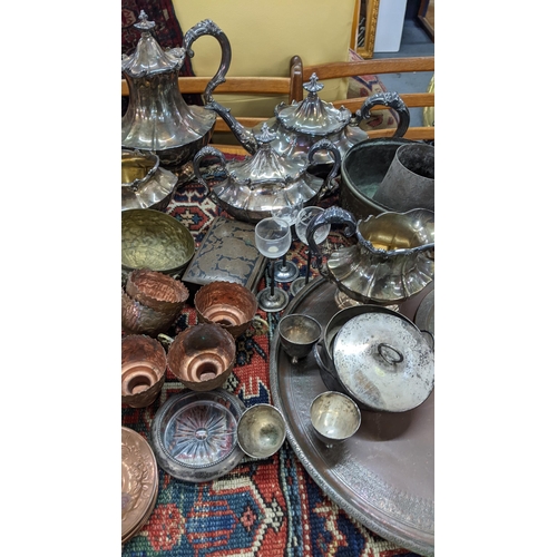 397 - Mixed metalware to include a silver plated tea service, pewter tankards, brass candlesticks and othe... 