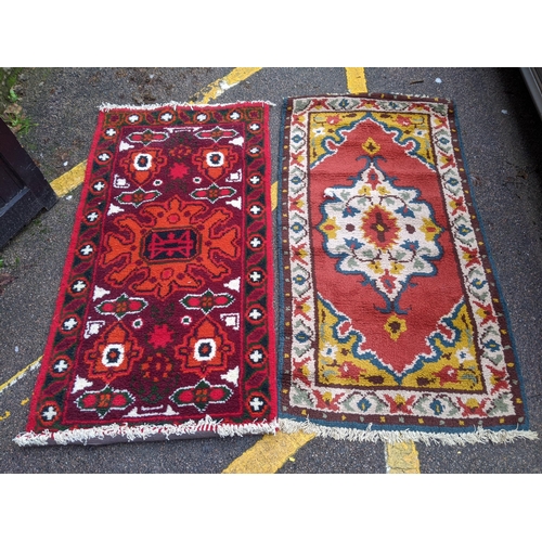 332 - Two rugs, one with a central floral decoration in a white emblem with white repeating border and an ... 