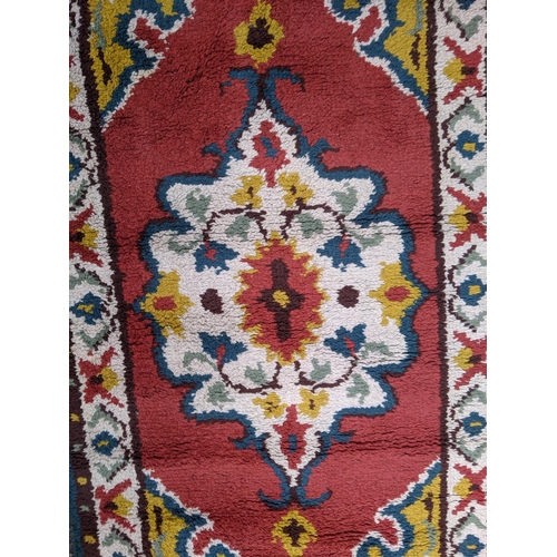 332 - Two rugs, one with a central floral decoration in a white emblem with white repeating border and an ... 