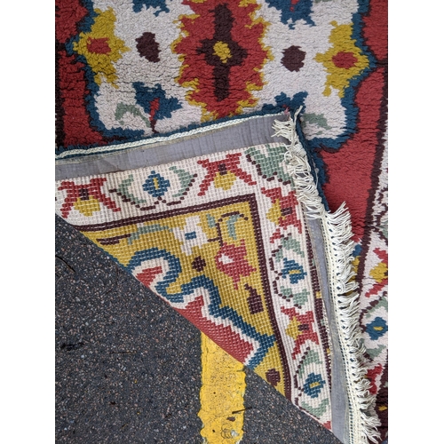 332 - Two rugs, one with a central floral decoration in a white emblem with white repeating border and an ... 