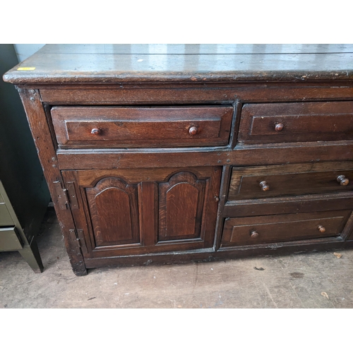 377 - A 17th century style oak dresser with three inline drawers, twin panelled doors and two drawers, 82c... 