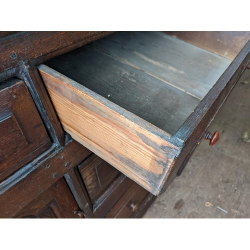 377 - A 17th century style oak dresser with three inline drawers, twin panelled doors and two drawers, 82c... 