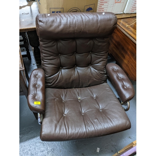 446 - An Ekornes Stressless brown button back leather style upholstered armchair on a tubular frame with s... 