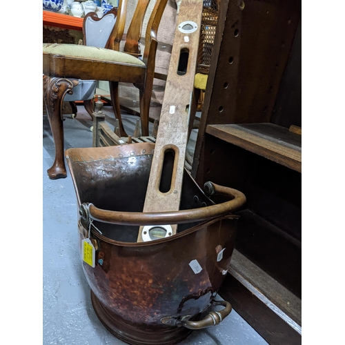 453 - An iron fire grate, Victorian copper coal scuttle and a wooden spirit level Location:G
If there is n... 