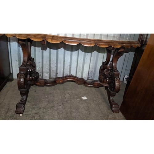 522 - A Victorian quarter cut veneered walnut oval loo table having marquetry inlaid and carved legs unite... 