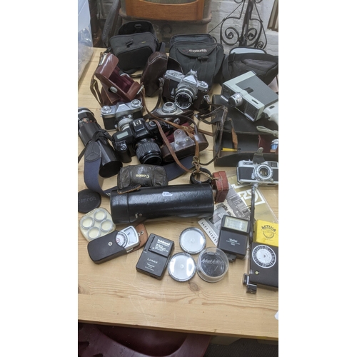 389 - A group of mixed vintage cameras to include a Canon E05 1000, a Contaflex, a Nikkor mat and others t... 