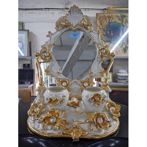 490 - A modern bathroom swivel ceramic mirror decorated with flowers and gilding with two pots in front of... 