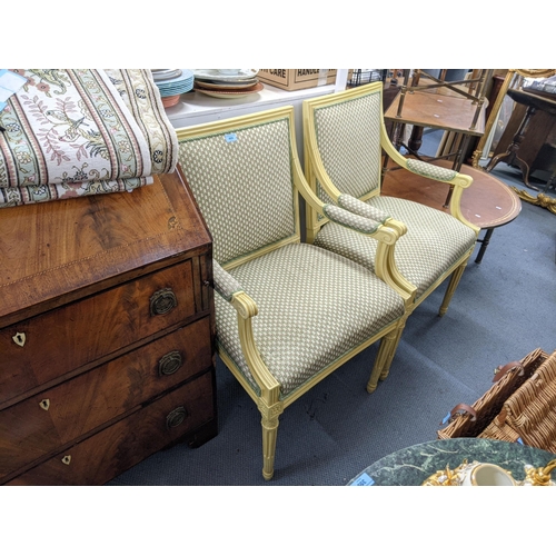 544 - A pair of pale yellow painted French style armchairs upholstered in floral fabric raised on tapering... 