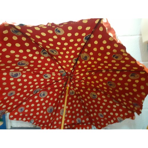 169 - A mid 20th Century large cotton tabletop parasol in red with wooden handle and metal clamp, approx 1... 