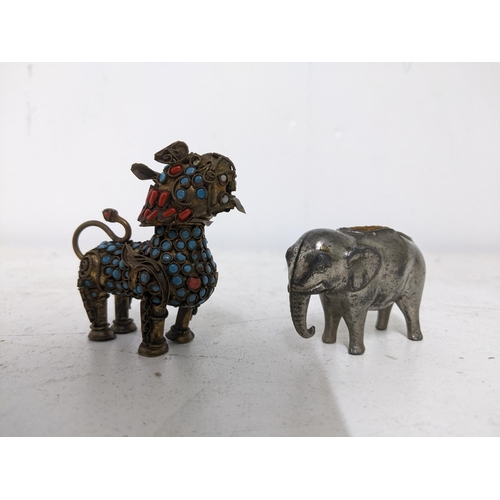 485 - A Victorian metal pin cushion in the form of an elephant, and a gilt metal Tibetan lion dog figure i... 