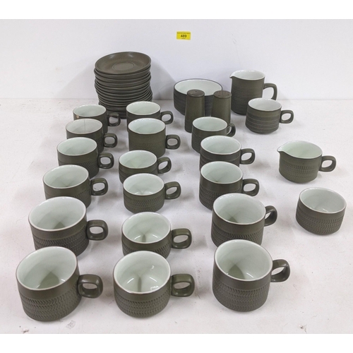 489 - A part Denby tea service with fourteen saucers, mugs, four smaller cups, a bowl, a jug, salt and pep... 