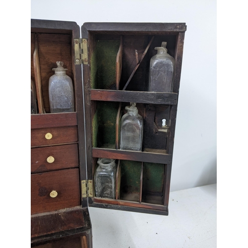 512 - An early 20th century mahogany portable medicine cabinet with nine glass bottles
Submission referenc... 