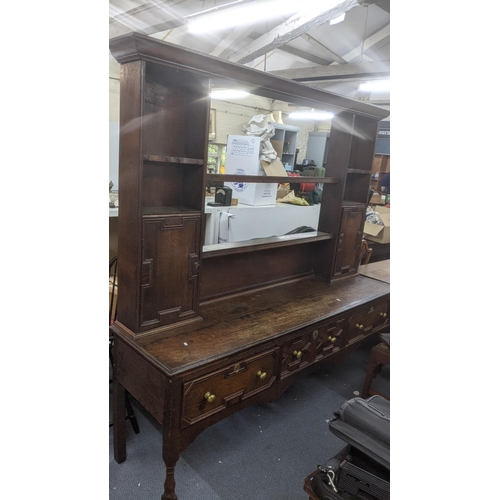 565 - Early 1700s oak dresser with shelves, pair of panelled doors, three in-line drawers on turned tapere... 