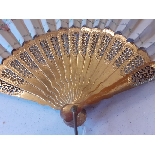 22 - An early 20th Century fan having 2 gilt wooden guards and 14 sticks and cream hand-painted leaves de... 