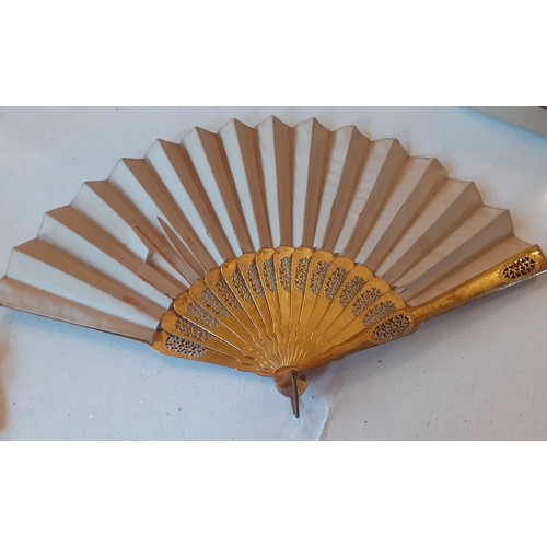 22 - An early 20th Century fan having 2 gilt wooden guards and 14 sticks and cream hand-painted leaves de... 