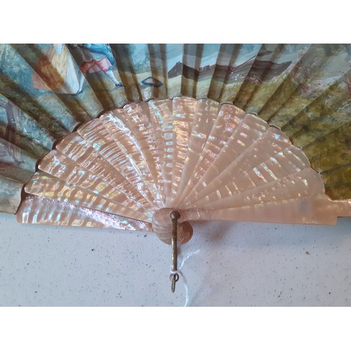 23 - An early 20th Century fan having 2 cream pearlised guards and 14 sticks A/F with hand-painted paper ... 