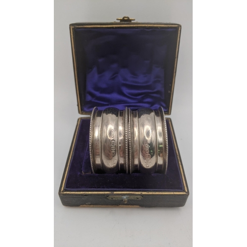 115 - Six silver napkin rings to include a pair in a fitted case, a floral embossed example, two engraved ... 