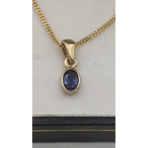 151 - A two piece blue sapphire and 9ct yellow gold suite to include an oval cut blue sapphire pendant on ... 