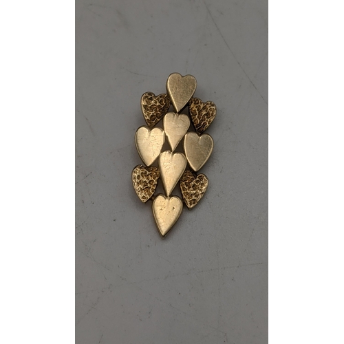 157 - A yellow gold pendant tested as 9ct fashioned as a cluster of love hearts, along with a 9ct gold cha... 