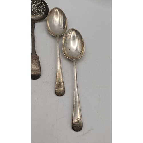 163 - Silver to include two sugar sifters and a pair of Kemp Brothers table spoons, hallmarked London 1935... 