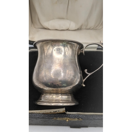 174 - A silver christening mug 44.9g in a fitted case, together with a white metal small engraved pot, tot... 