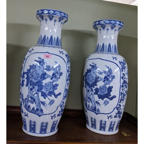 282 - Pair of modern Oriental blue and white porcelain vases, panels of birds amongst blossoming foliage s... 