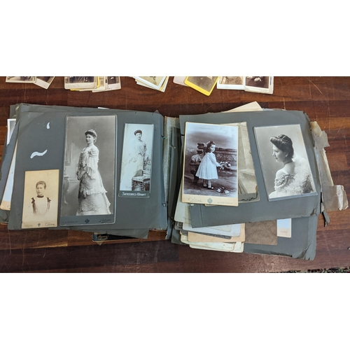 320 - An early 20th century black and white photo album, along with some Victorian photograph cards Locati... 