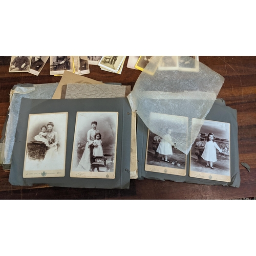 320 - An early 20th century black and white photo album, along with some Victorian photograph cards Locati... 