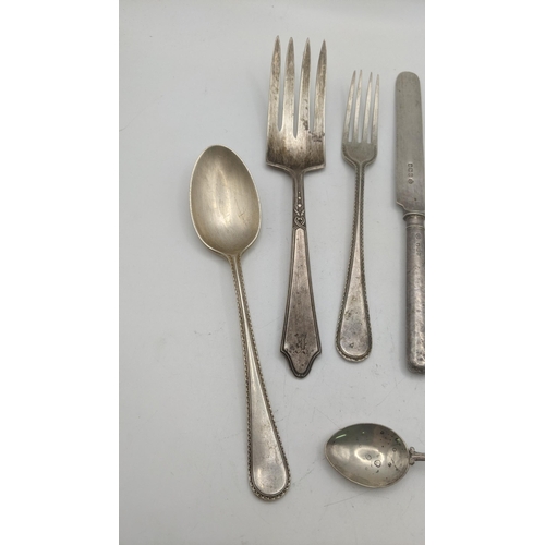 87 - Silver cutlery and flatware to include two sauce ladles, a butter knife with weighted handle, a ster... 