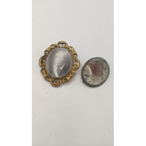 18 - A Victorian gold plated mourning brooch, together with a red and green moss agate and cabochon mount... 