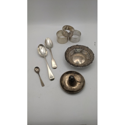 23 - Silver to include three napkin rings , two teaspoons, a floral pierced pin dish, a salts spoon and a... 