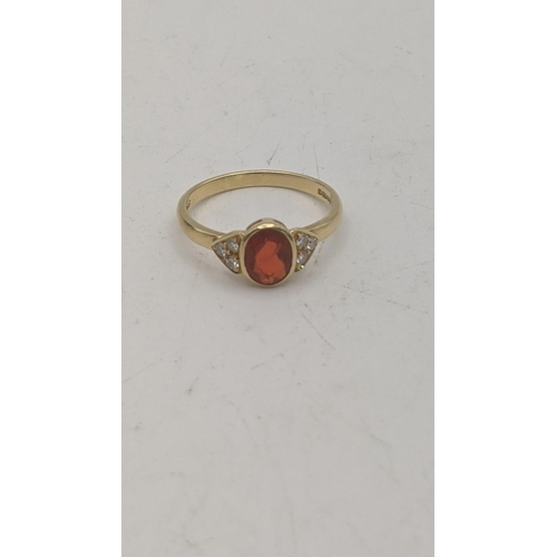 42 - An 18ct yellow gold orange stone and six diamond ring, central oval cut orange stone and shoulders s... 