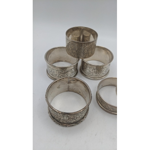 48 - Silver napkin rings of various examples to include a pair of floral engraved napkin rings, hallmarke... 