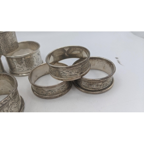 48 - Silver napkin rings of various examples to include a pair of floral engraved napkin rings, hallmarke... 