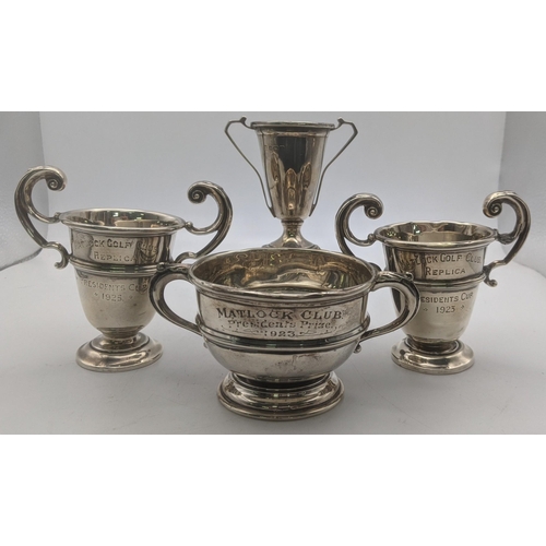 62 - Four silver trophy cups three inscribed to Matlock gold club along with one other example on a pedes... 