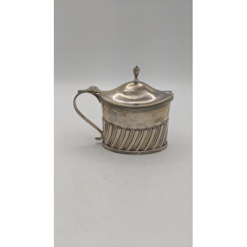 64 - A Thomas Bradbury and sons silver mustard pot hallmarked London 1899, with a blue glass liner weight... 