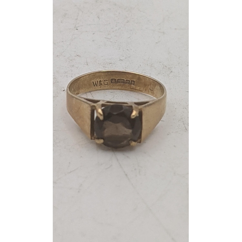 194 - Two 9ct yellow gold ladies rings to include a brilliant cut smoky quartz example, and a wedding band... 