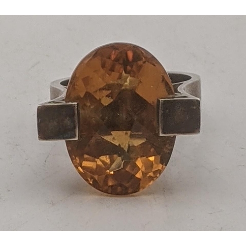 196 - An oval faceted cut Brazilian citrine in a silver two prong setting, stamped sterling to the shank
L... 