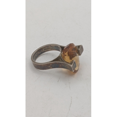 196 - An oval faceted cut Brazilian citrine in a silver two prong setting, stamped sterling to the shank
L... 