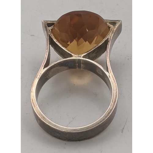 196 - An oval faceted cut Brazilian citrine in a silver two prong setting, stamped sterling to the shank
L... 