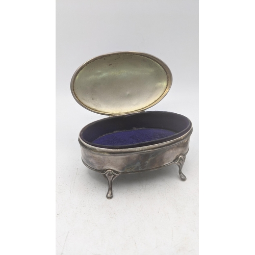 200 - Two silver dressing table items to include an oval shaped ring box on four feet having a hinged lid ... 