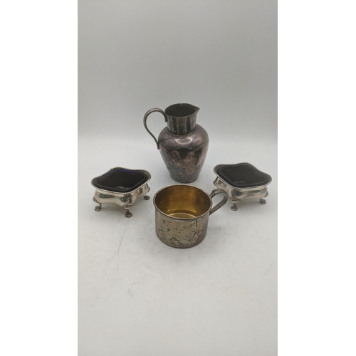 215 - Silver to include a pair of condiment pots on four claw feet with blue glass liners, together with a... 