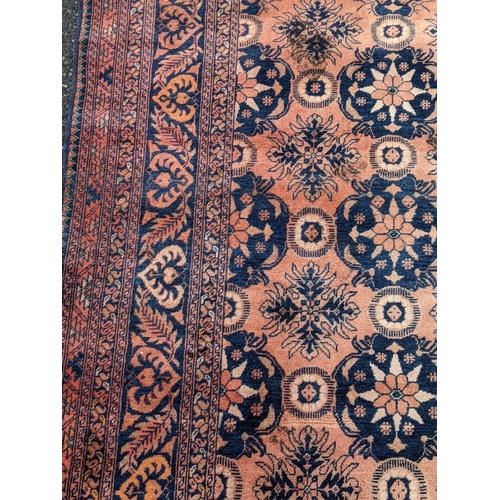 343 - An Afghan rug decorated with three central floral emblems on a red background, 127cm w x 200 cm l A/... 