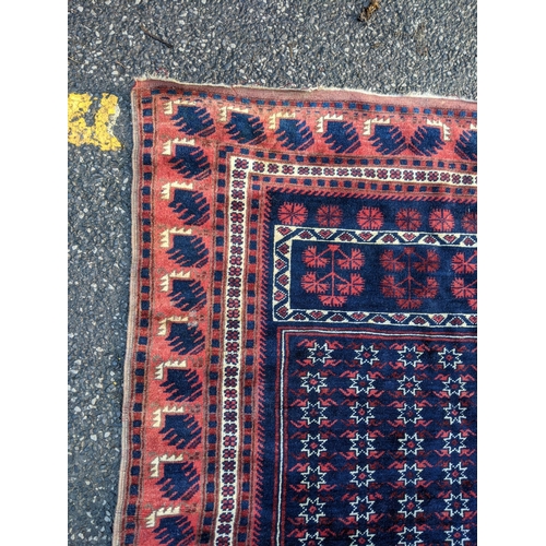 357 - A Persian rug decorated with repeating gulls with a red border on a blue background, 178cm 1 x 190cm... 