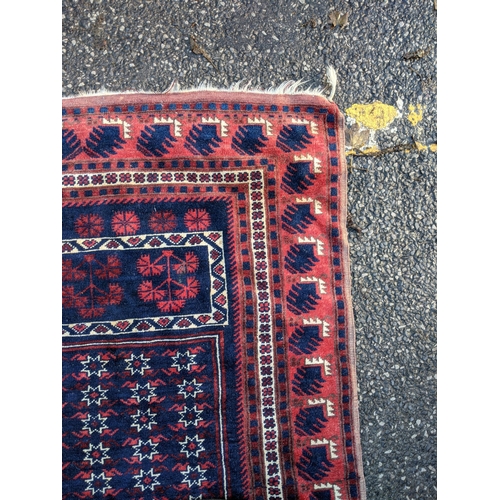 357 - A Persian rug decorated with repeating gulls with a red border on a blue background, 178cm 1 x 190cm... 